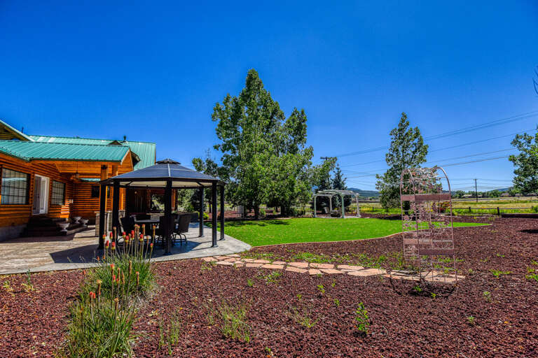 Enjoy outdoor dining with a table for 6 under the backyard gazebo.