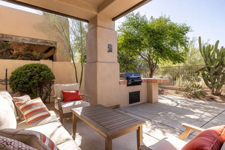 Enjoy your own private patio retreat with comfortable seating, a built-in grill, and serene desert views perfect for relaxing or dining outdoors.