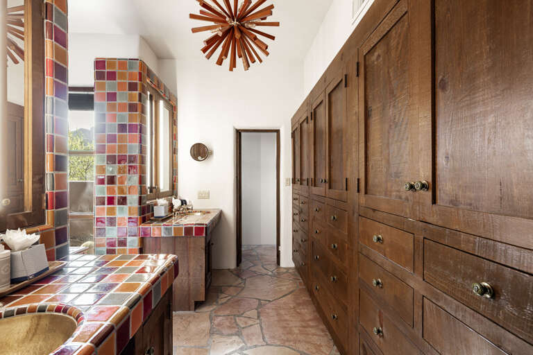 Ample custom cabinetry, handcrafted tile, and premium finishes provide both style and functionality in the spacious primary bathroom.
