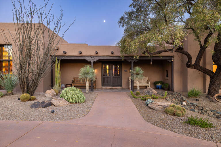 Arrive through a beautifully landscaped entry with mature desert plants, creating a warm welcome to this one-of-a-kind luxury retreat.