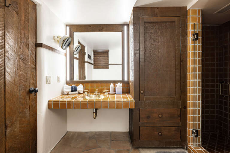 A beautifully crafted vanity with handcrafted tile, custom cabinetry, and plenty of space to get ready in comfort and style.