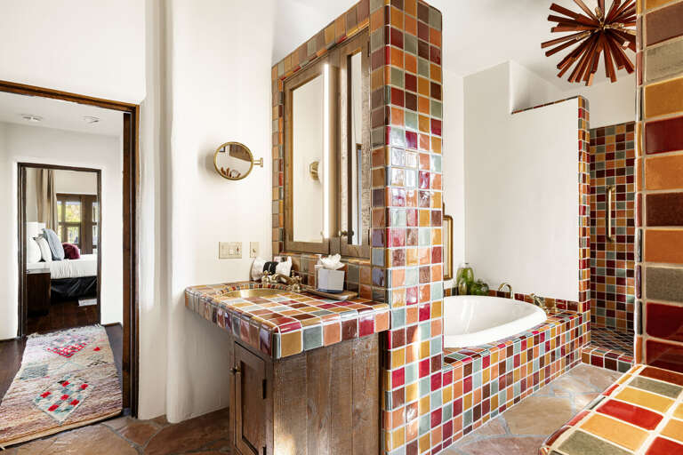 The luxurious primary bath features dual vanities, handcrafted tilework, and a relaxing soaking tub for a true spa-like experience.