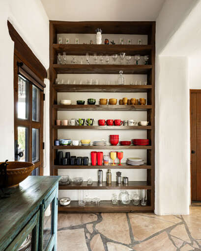 Open shelving keeps dishes, glassware, and cookware within easy reach, making meal prep and entertaining effortless.
