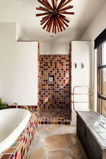 Unwind in the luxurious primary bathroom featuring a soaking tub, handcrafted tile, and a spacious walk-in shower.
