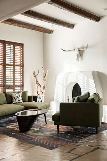 Unwind beside the traditional kiva fireplace, where cozy seating and warm desert-inspired design create the perfect retreat.