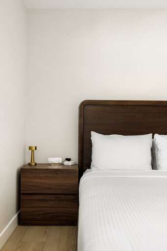 Bedroom detail featuring warm wood accents, soft lighting, and clean modern design touches.
