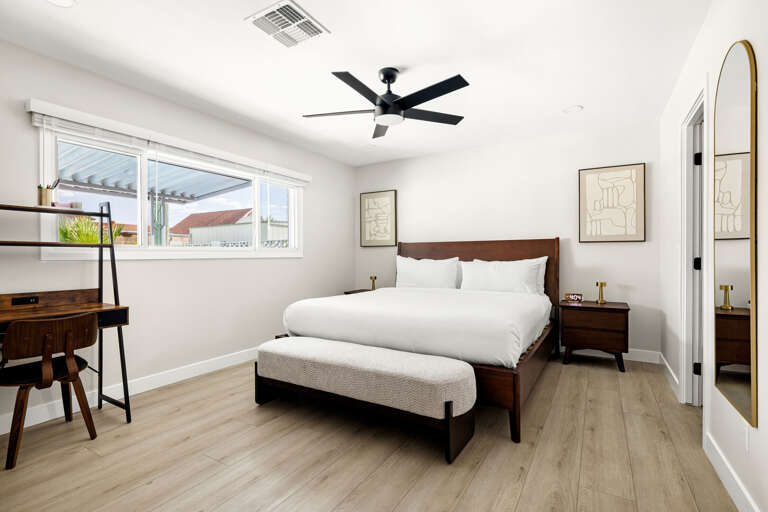 Bright and comfortable bedroom featuring modern furnishings and large windows for natural light.