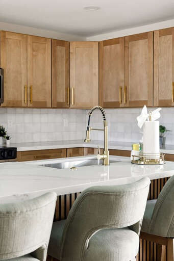 Elegant kitchen details featuring quartz countertops, modern fixtures, and warm wood cabinetry.