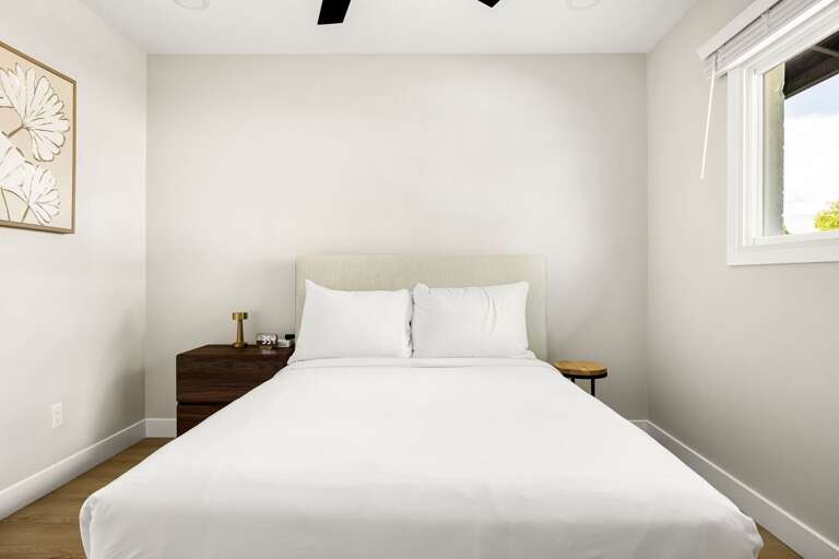 Minimalist bedroom with plush bedding and a calm, peaceful atmosphere perfect for unwinding.