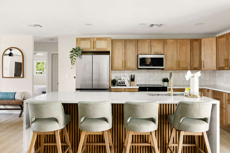 Modern chef's kitchen featuring quartz countertops, bar seating, and an open entertaining layout.