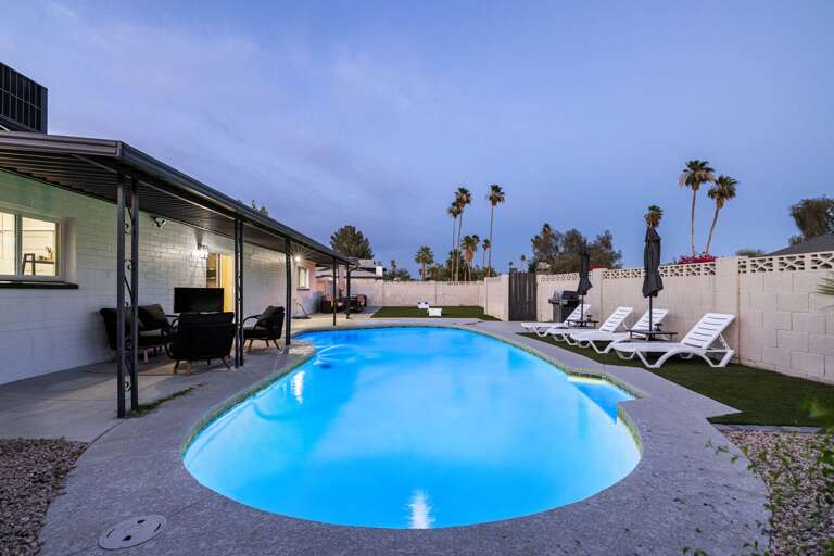 Private resort-style pool illuminated at dusk, creating a peaceful and inviting nighttime atmosphere.