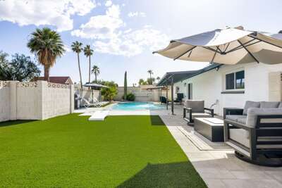 Spacious backyard with outdoor seating, lush turf, and plenty of room to relax and enjoy the sunshine.