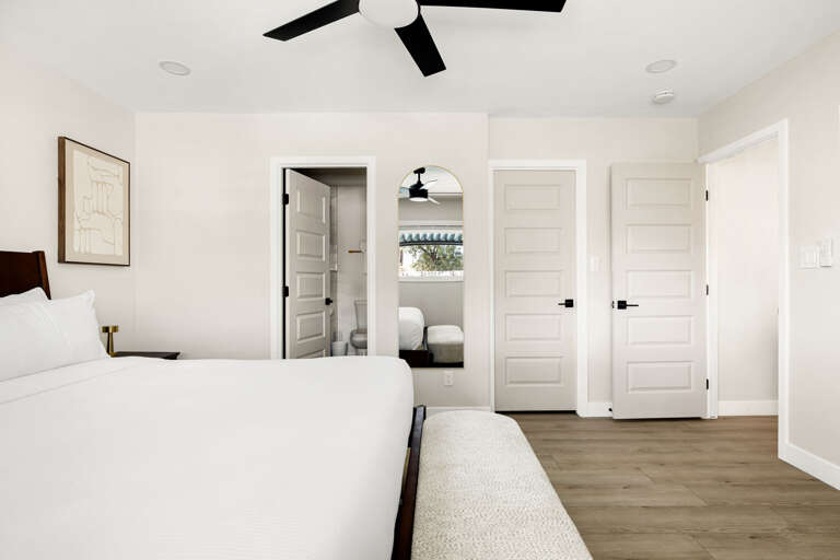Spacious bedroom featuring clean contemporary design, cozy furnishings, and ample storage space.