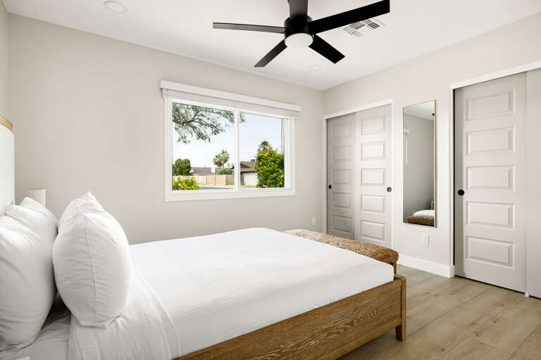 Spacious modern bedroom with large windows, contemporary décor, and a relaxing atmosphere.