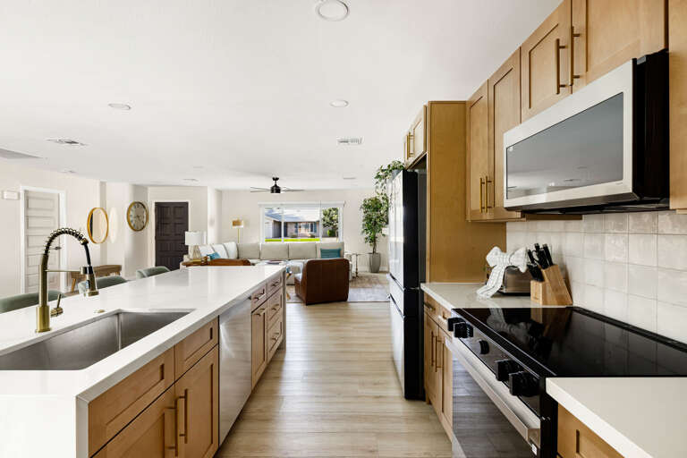 Spacious open kitchen with oversized island, modern appliances, and seamless flow into the living area.