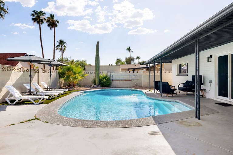 Sunny backyard oasis with private pool, lounge chairs, and plenty of space to relax and unwind.