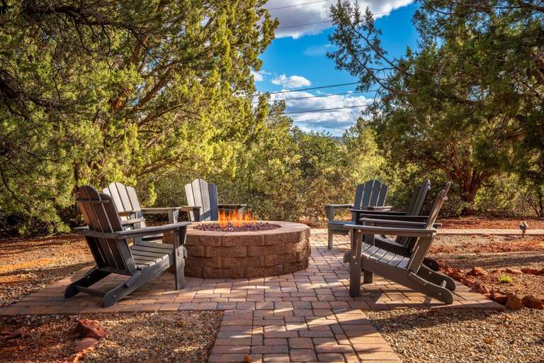 Gather around the outdoor fire pit beneath the stars, surrounded by towering trees and comfortable