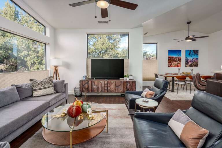 Relax in this sun-soaked great room with soaring ceilings, designer furnishings, and seamless open-concept living.