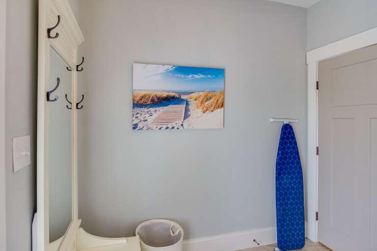 Laundry room with iron, ironing board and laundry detergent.