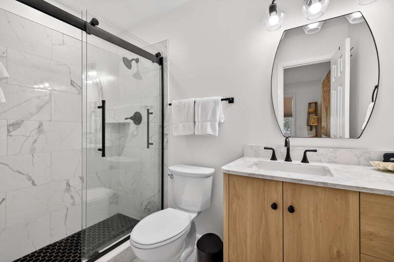 Remodeled bathroom with new walk-in shower, sliding glass door, new fixtures and new vanity.