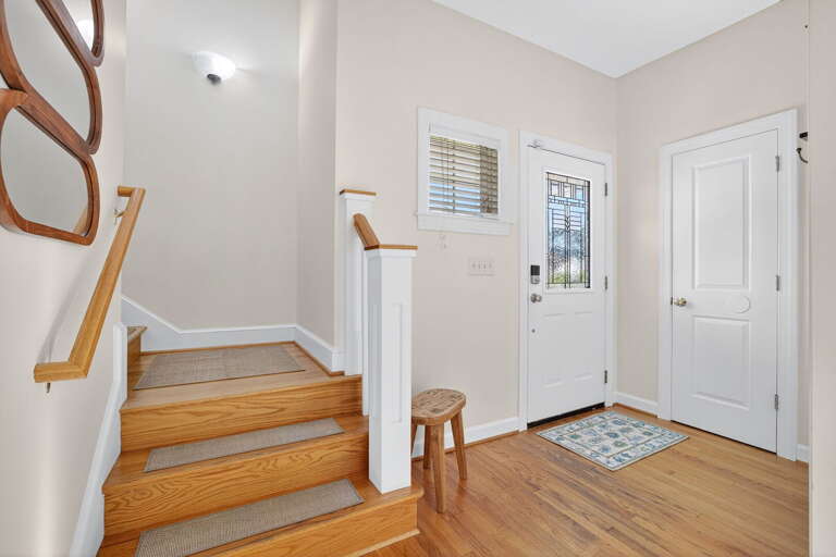 Main entrance with a peak of the staircase leading to the Primary Bedroom spread. Main entrance with a peak of the staircase leading to the Primary Bedroom spread.