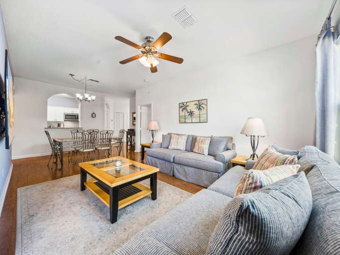 Spacious Living Room With Sofas, Ceiling Fan, Dining Area, And Kitchen