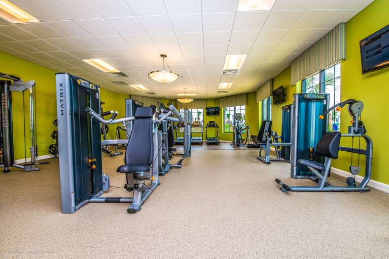 Brightly-lit Fitness Facility With Green Walls And Multiple Exercise Machines