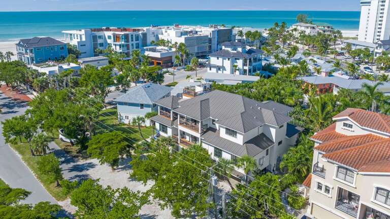 Aerial View Of A Seaside Vacation Rental Surrounded By Palms