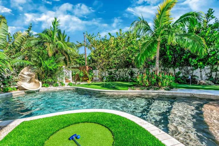 Tropical Poolside Paradise With Lush Greenery And A Shell-shaped Fountain