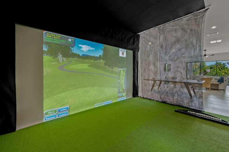 Indoor Golf Simulator Room With Large Screen And Green Carpet