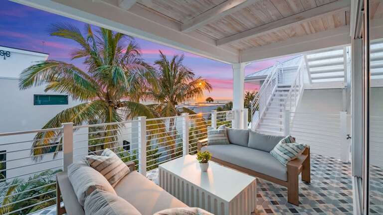 Patio Paradise With Plush Seating, Sunset Skies, And Swaying Palms