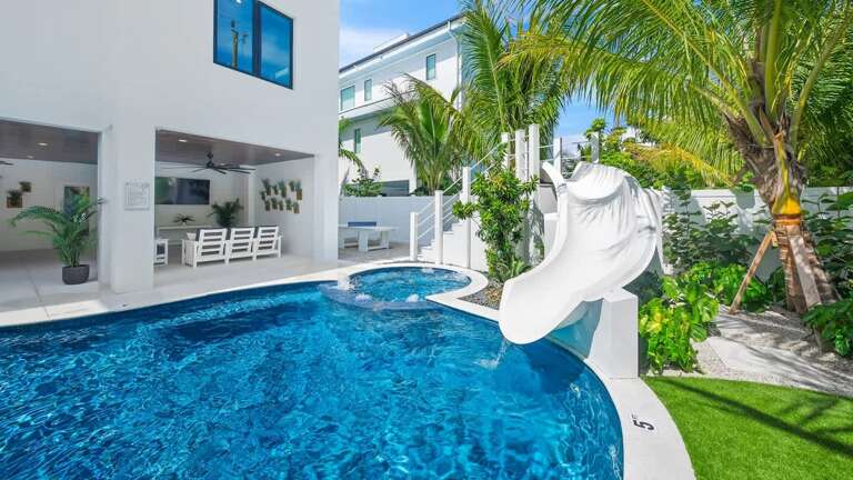 White Building Beside Blue Pool With Palm Trees