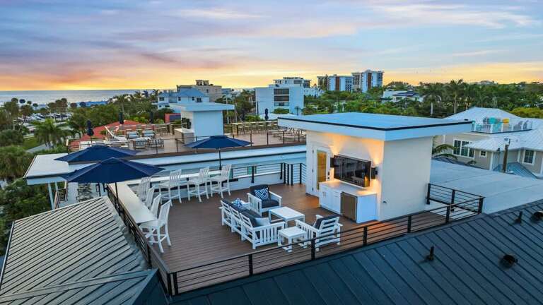 Rooftop Terrace With Seating Under Umbrellas At Sunset