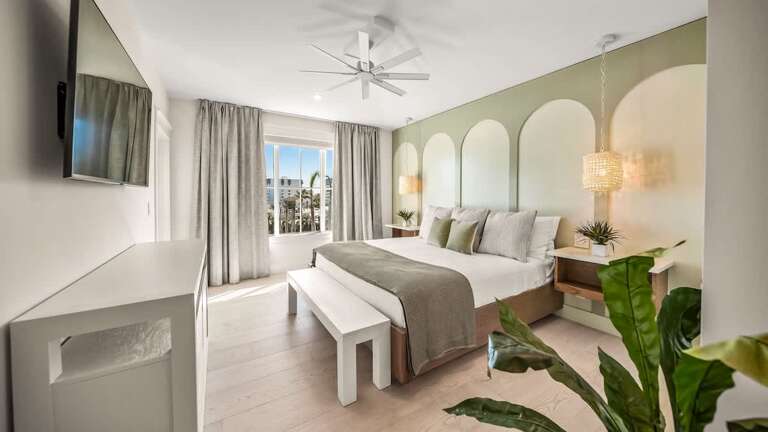 Spacious Suite Showing Serene Sleeping Space, Subtle Shades, And Sunlit Scenery Sliding Through Sheer Curtains