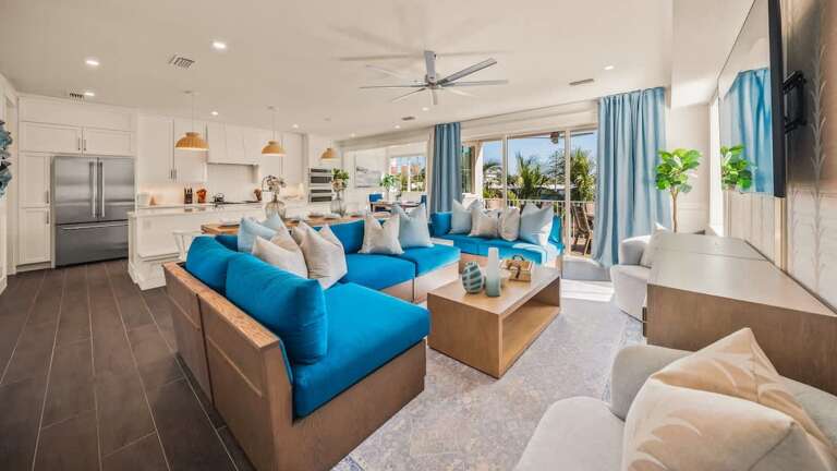 Bright Blue Sofas, Spacious Living Room, Kitchen Island, Sliding Glass Door To Balcony