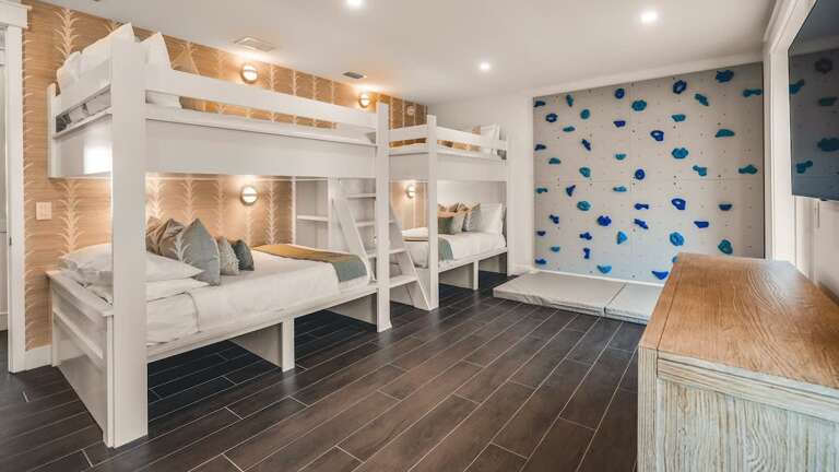 Vacation Rental Room With Multiple Beds And Blue-patterned Wall