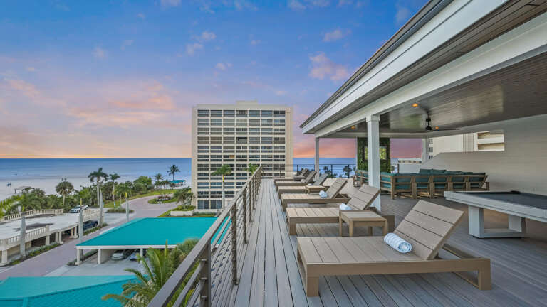 Seaside Balcony View With Loungers Overlooking Pools And Palms