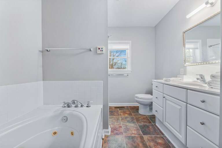 The ensuite bathroom features a jet tub and shower, along with a double vanity.