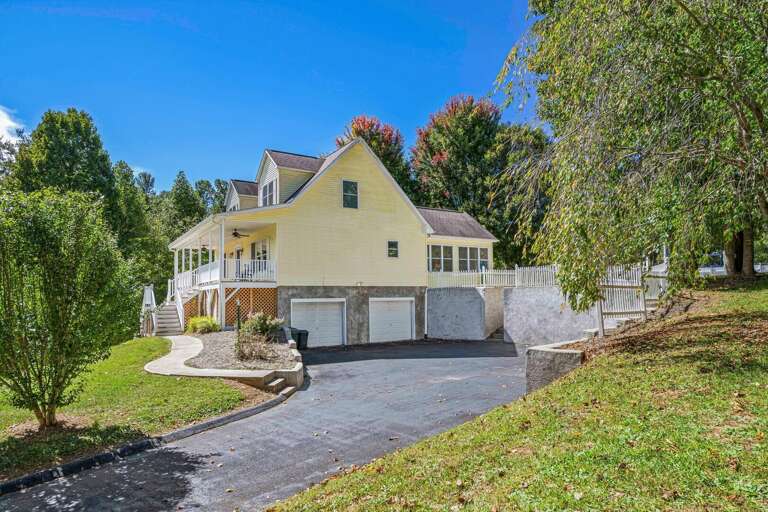 The large drive accommodates multiple cars. Stairs connect the driveway to the backyard, providing quick access between the games in the garage and your outdoor fun.