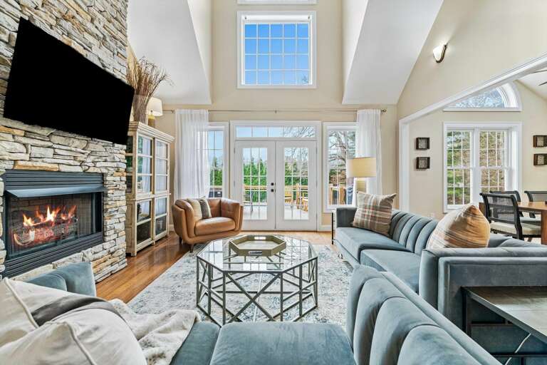 Living Room With Fireplace, Sofas, And Large Windows