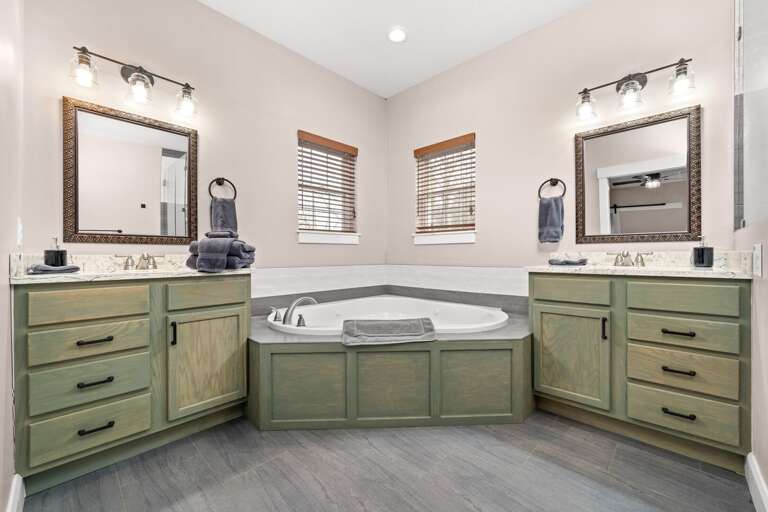 The ensuite bathroom features a jet tub and large walk-in shower, along with two vanities.