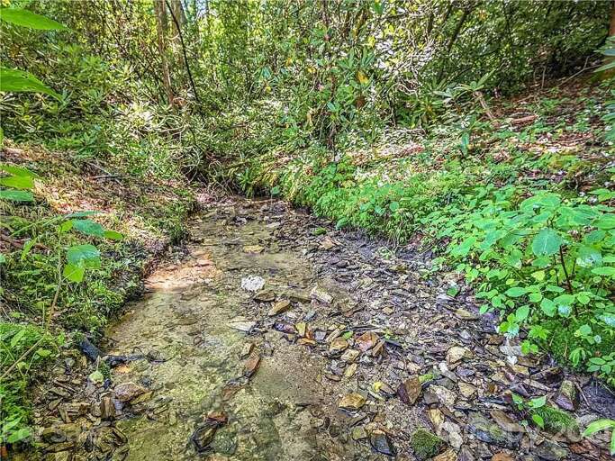 Savor your morning coffee alongside a peaceful creek that runs down the side of the property.