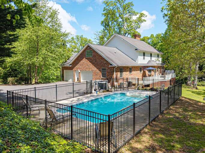 [Outdoor Pool] Enjoy sunny days swimming in the gated outdoor pool set against a scenic forest backdrop.