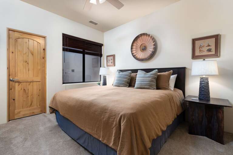Bedroom With Beige Bedding, Wooden Door, And Soft-hued Decor