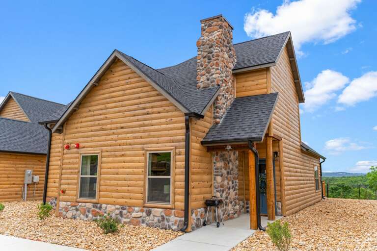 Wooden Residential House With Stone Chimney And Blue Sky
