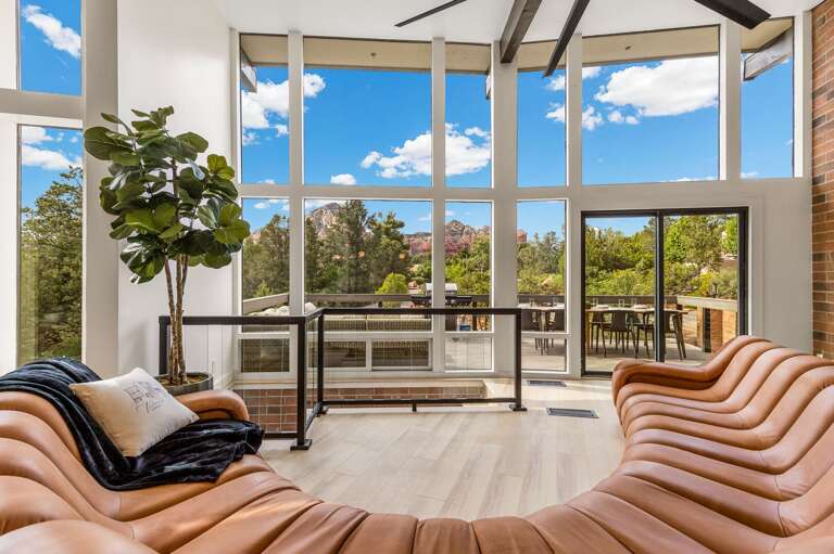 Interior Of A Vacation Rental Living Room With Large Windows And Terrace View