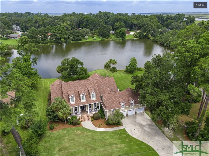 Aerial View Of A Lakeside Residence Surrounded By Greenery