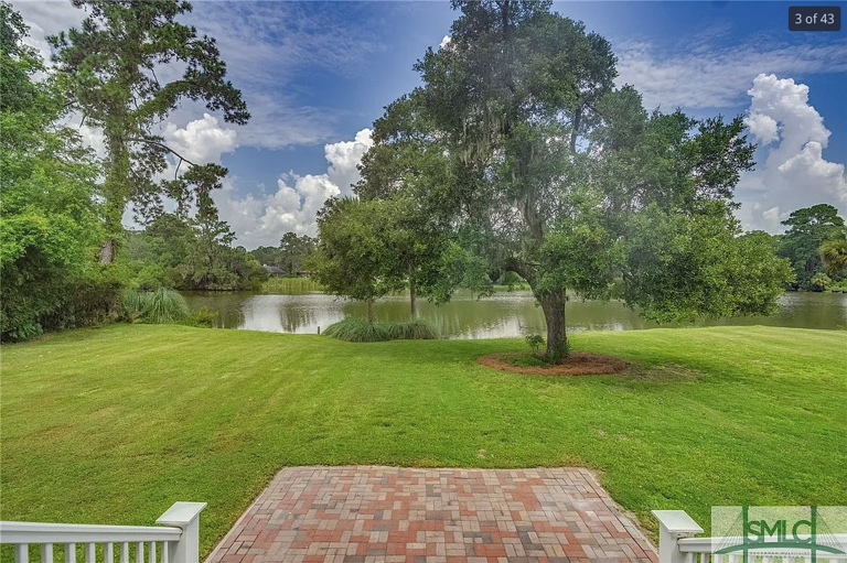 Lush Landscape With Lake, Tree, And Brick Patio