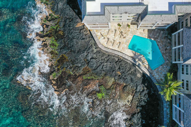 Aerial View Of A Building With A Pool By The Sea