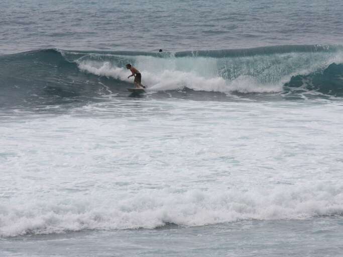 Surfer Skims Seas Sweeping Swells